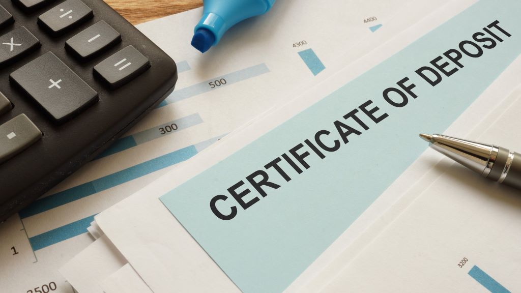 Certificate of deposit on a desk with other papers and a calculator.